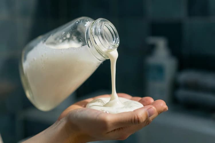 Close-up de shampoo sendo derramado em uma mão para o banho de um cachorro